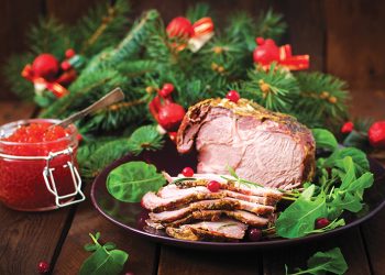 Christmas baked ham and red caviar, served on the old wooden table.