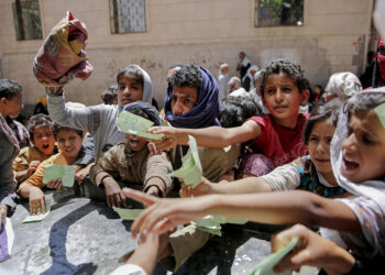 Foto de abril de 2017 mostra iemitas apresentando documento para receber comida de organização de caridade em Sanaa — Foto: Hani Mohammed, File/AP Photo