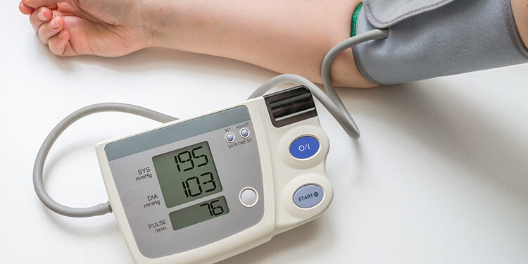 Hypertension concept. Man is measuring blood pressure with monitor. Isolated on white background.