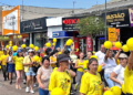 Grupo de moradores do Tatuquara em Curitiba usando camisetas amarelas em caminhada de conscientização do Setembro Amarelo.