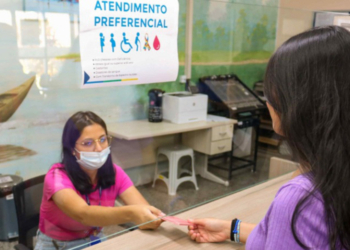 Símbolo da borboleta roxa para fibromialgia em placa de atendimento preferencial no Paraná.