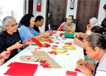 Mulheres participam da confraternização de encerramento do projeto "Café com Artesanato" do Grupo Geração Solidária em dezembro de 2025.