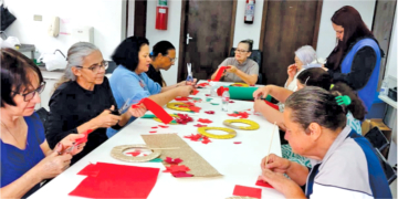 Mulheres participam da confraternização de encerramento do projeto "Café com Artesanato" do Grupo Geração Solidária em dezembro de 2025.