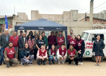 Reunião comunitária em Curitiba com moradores sendo orientados por profissionais em um Fórum Comunitário ao ar livre