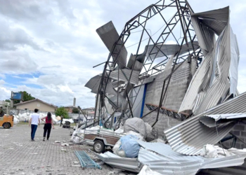 Estrutura metálica de galpão retorcida e destruída após vendaval no Paraná, ilustrando a necessidade de prevenção de desastres e a atuação da Defesa Civil.