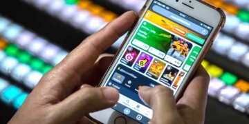 Pessoa utilizando celular com aplicativos de apostas, representando o risco de vício