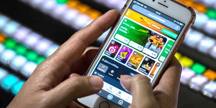 Pessoa utilizando celular com aplicativos de apostas, representando o risco de vício