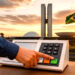 Eleitor votando na urna eletrônica com o Congresso Nacional em Brasília ao fundo.
