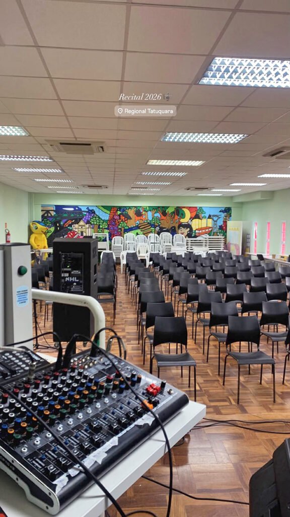 Auditório da Regional Tatuquara preparado com cadeiras e equipamentos de som para o recital.
