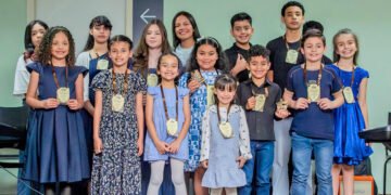 Participantes do recital da Escola de Música Partituras posam com medalhas no Tatuquara.