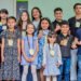 Participantes do recital da Escola de Música Partituras posam com medalhas no Tatuquara.